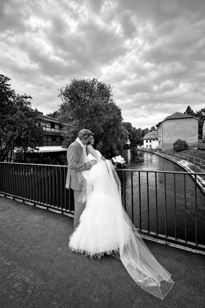Monika i Hass – Para młoda przy balustradzie nad rzeką – kadr czarno-biały