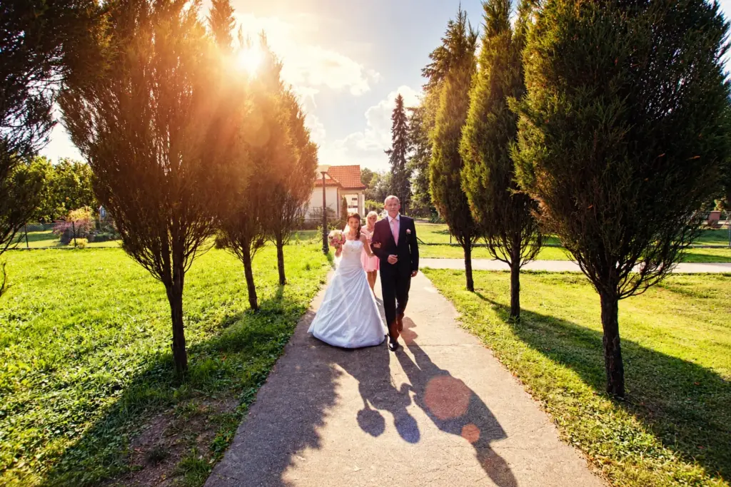 Sierpniowy ślub pod Bydgoszczą – Para młoda w alei drzew w drodze do kościoła