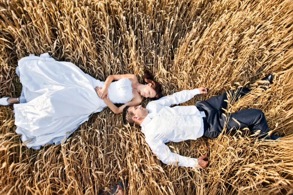 Sierpniowy ślub pod Bydgoszczą – Para młoda leży w złotym zbożu